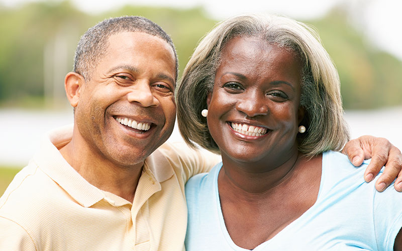 Photo of a happy African American senior couple smiling and looking at the camera